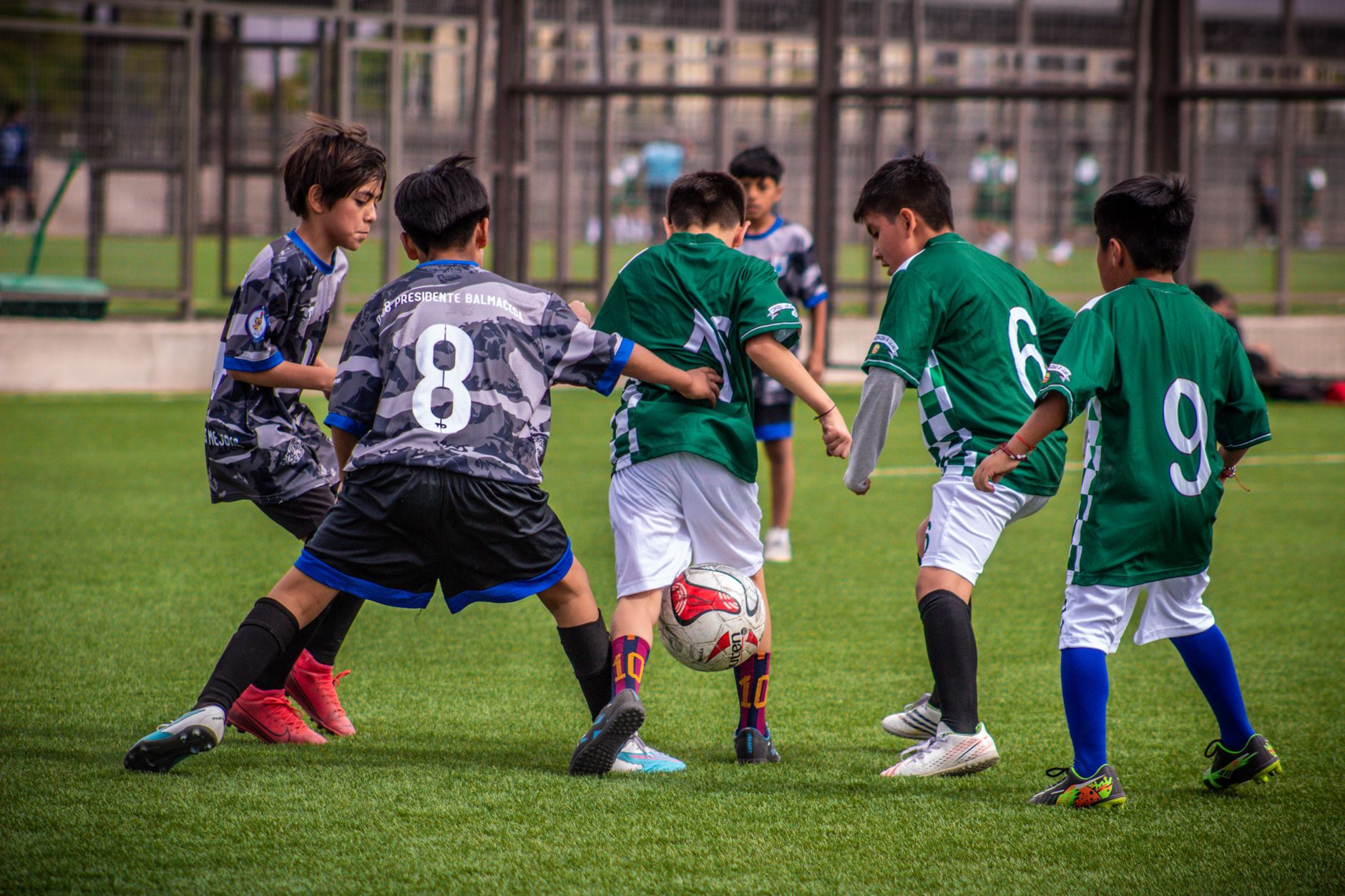 Young soccer players engaging in a dynamic football training session on a Chilean field.