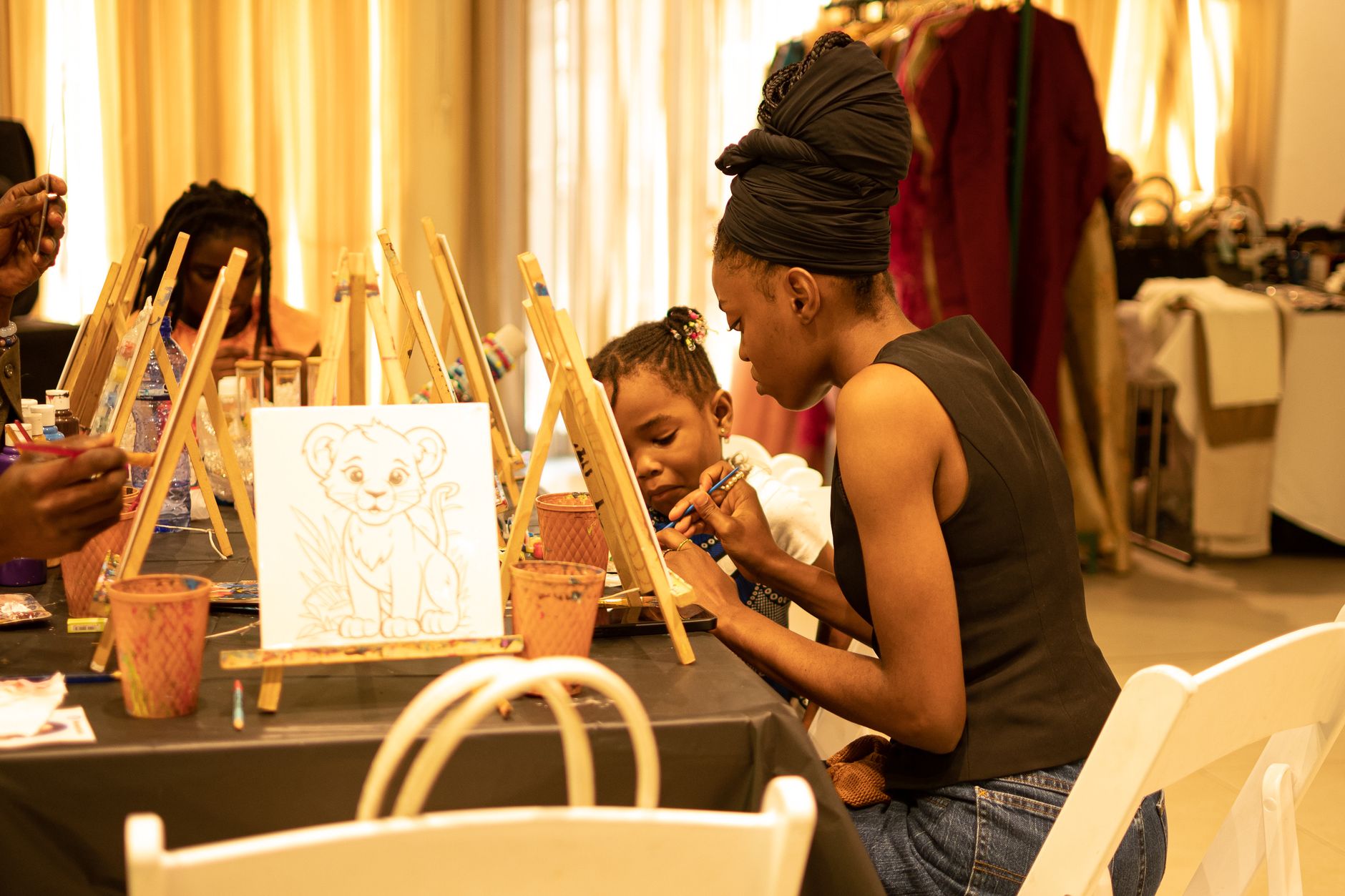 A dedicated mother paints with her child in an art workshop, fostering creativity together.