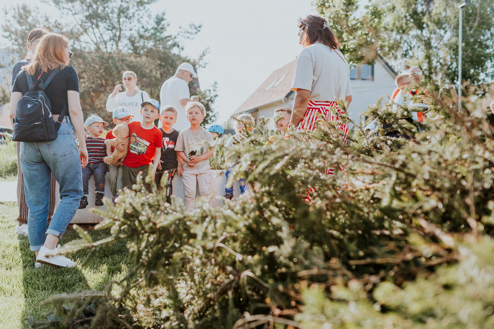 Children and adults participating in an outdoor educational activity surrounded by nature.