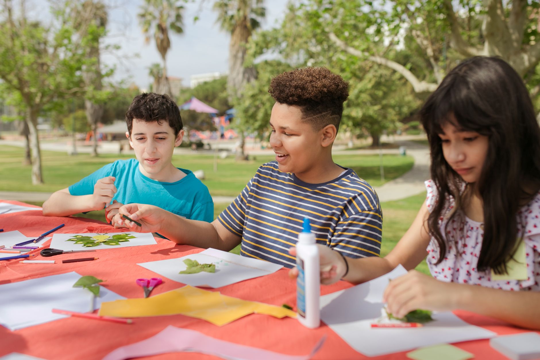 Kids creating art projects at an outdoor summer camp.
