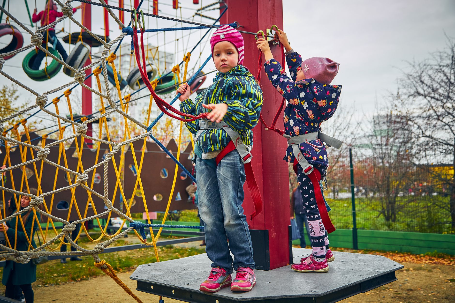 Two children enjoying a climbing adventure at an outdoor playground. Fun and safety combined!