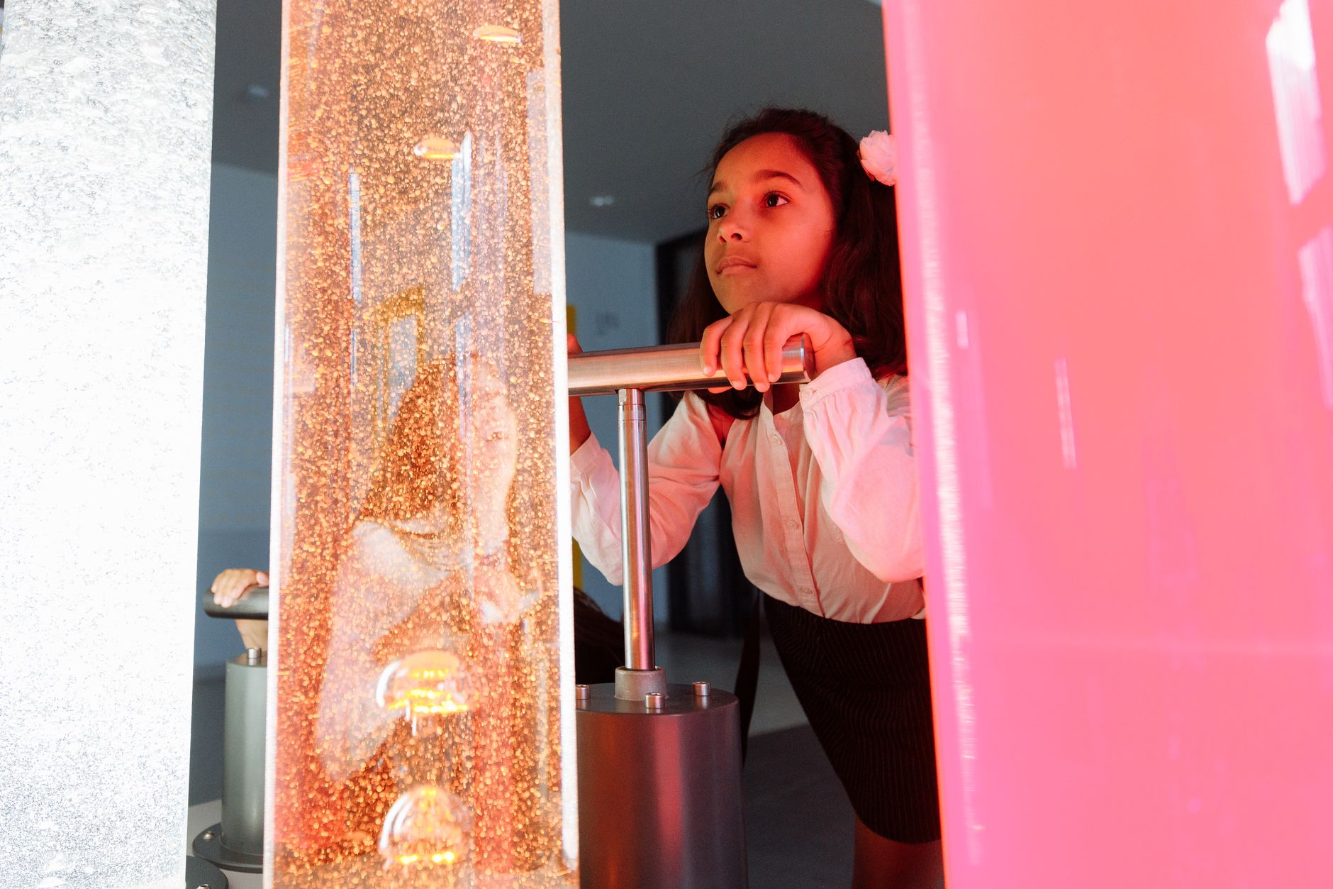 A curious child engages with a colorful interactive exhibit at a science museum.