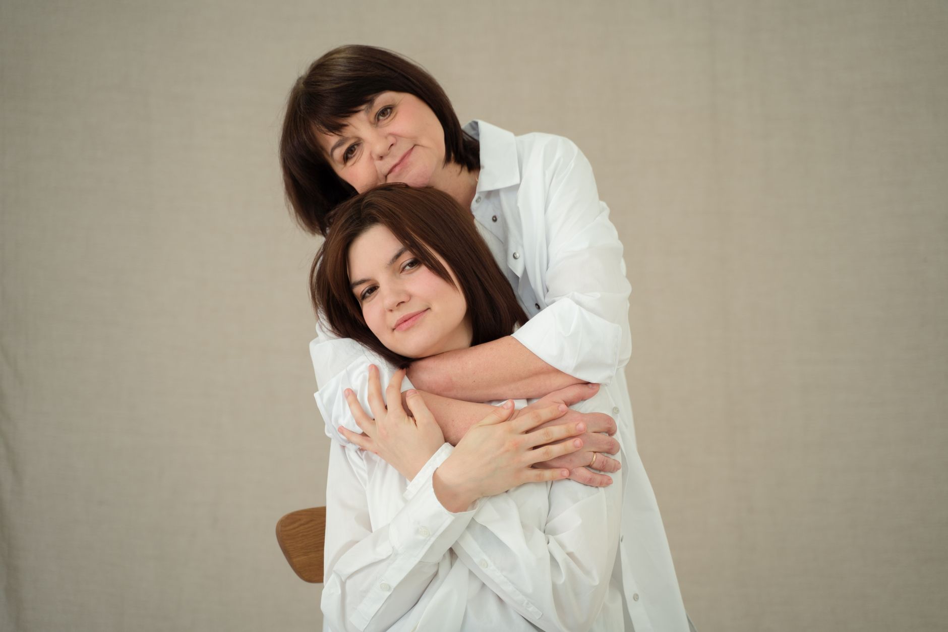 A heartwarming studio portrait of a mother embracing her daughter with love and affection.