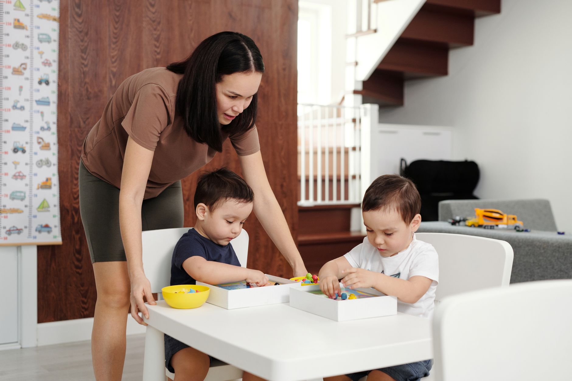 Mother spending quality time playing and learning with her kids indoors.