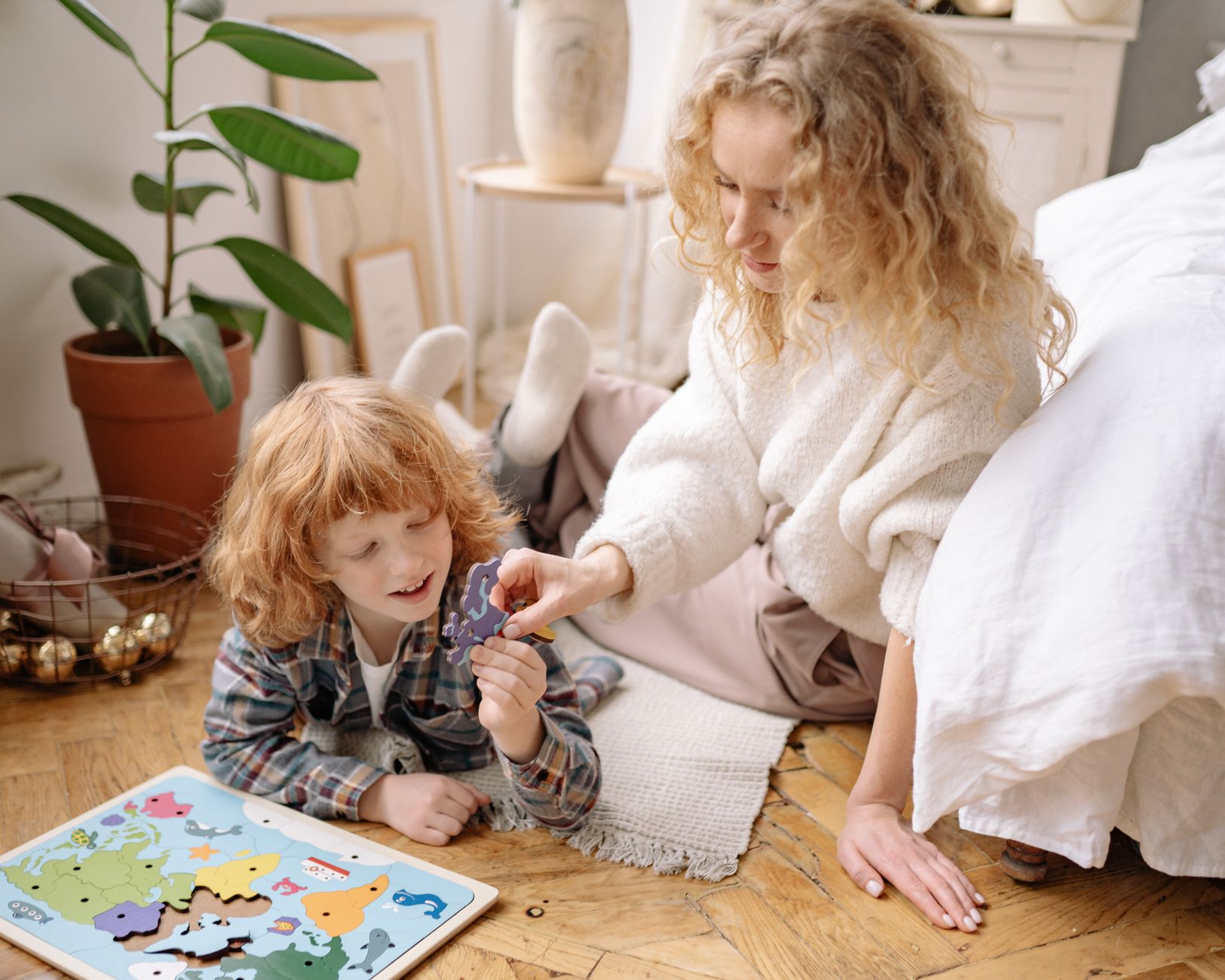 Mother and son enjoying a playful and educational moment indoors with a colorful puzzle.