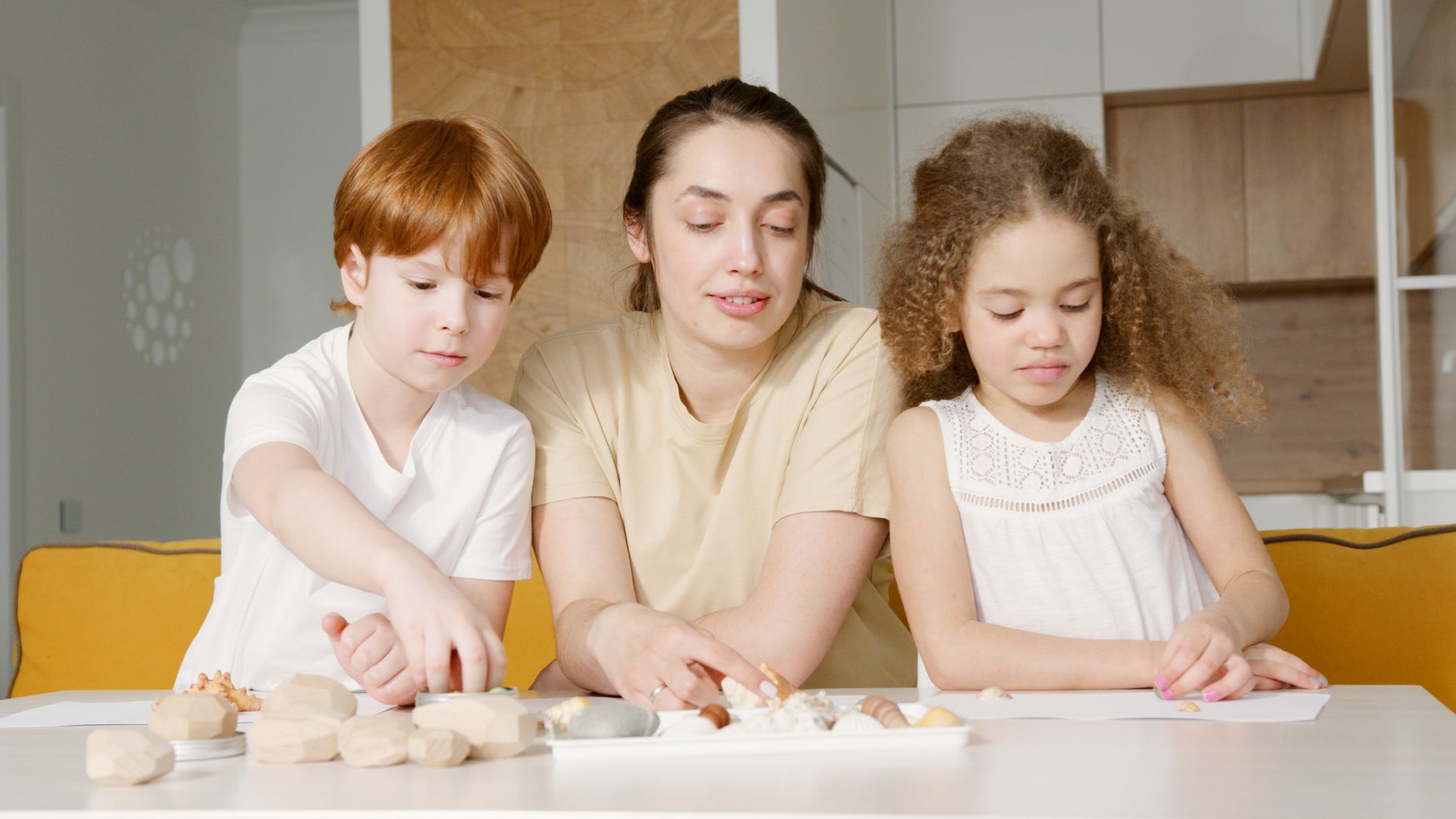 Mother and children engaged in a creative activity at home, fostering bonding and togetherness.