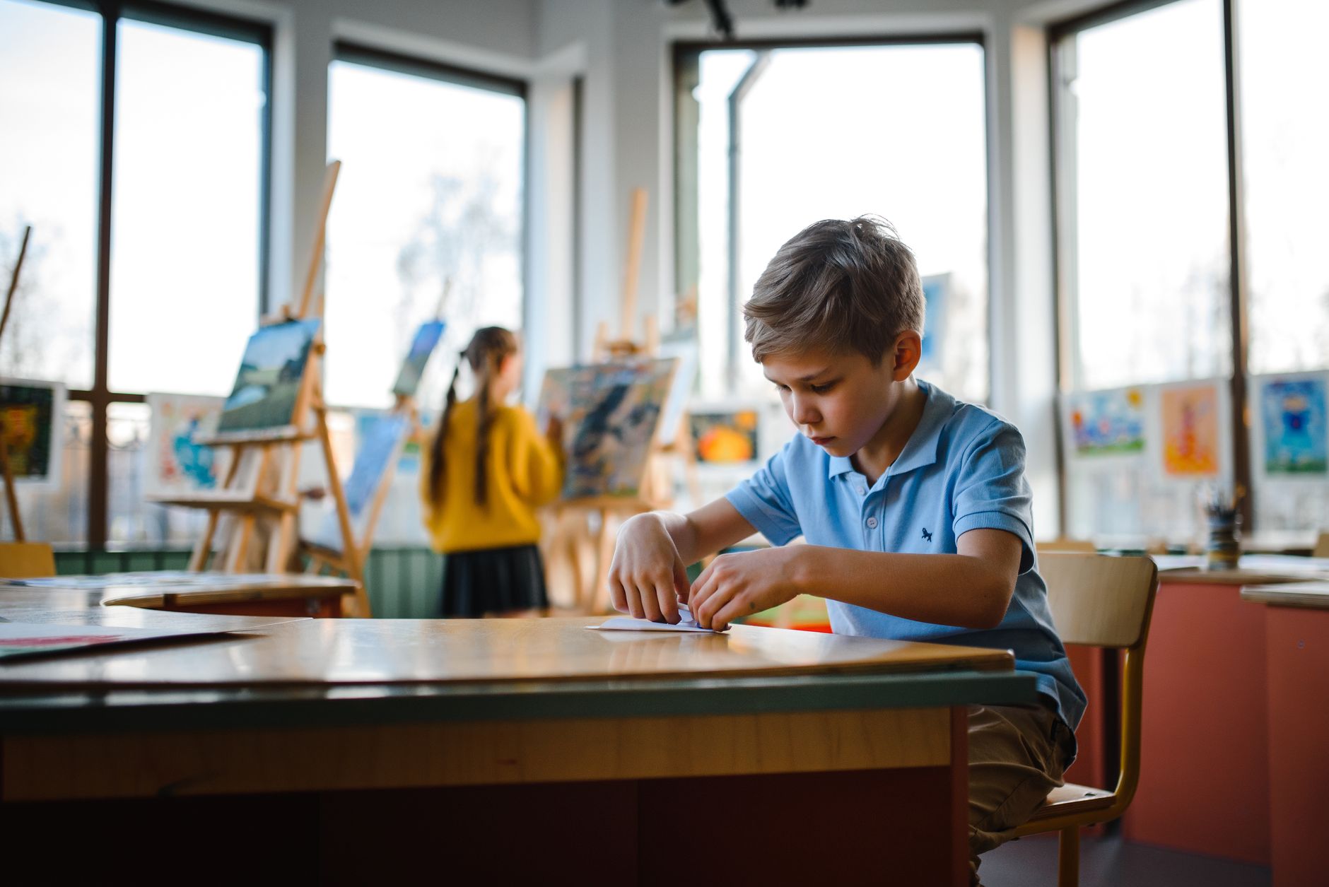 Kids participating in creative art activities in a bright classroom.