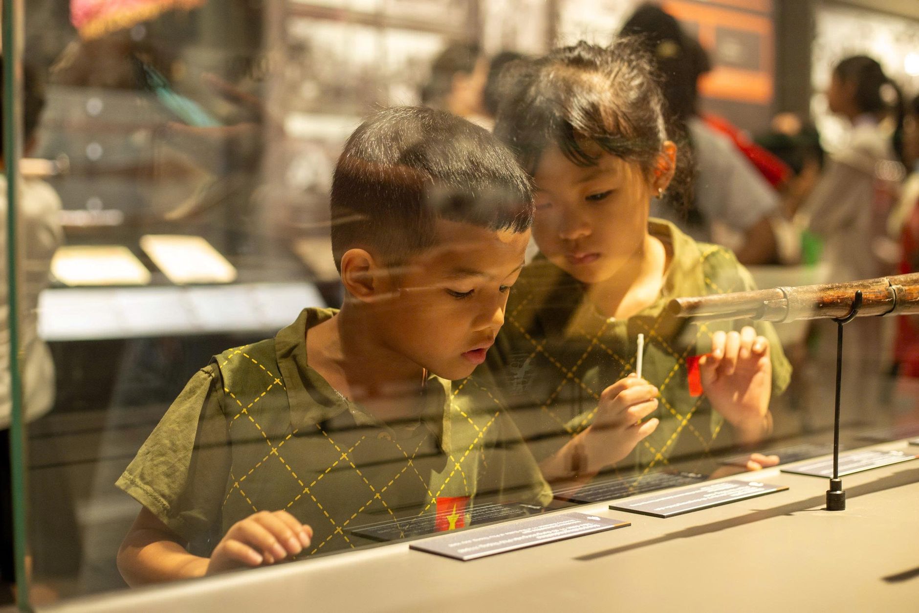 Engaged children exploring a museum exhibit in Hanoi, showcasing education and curiosity.