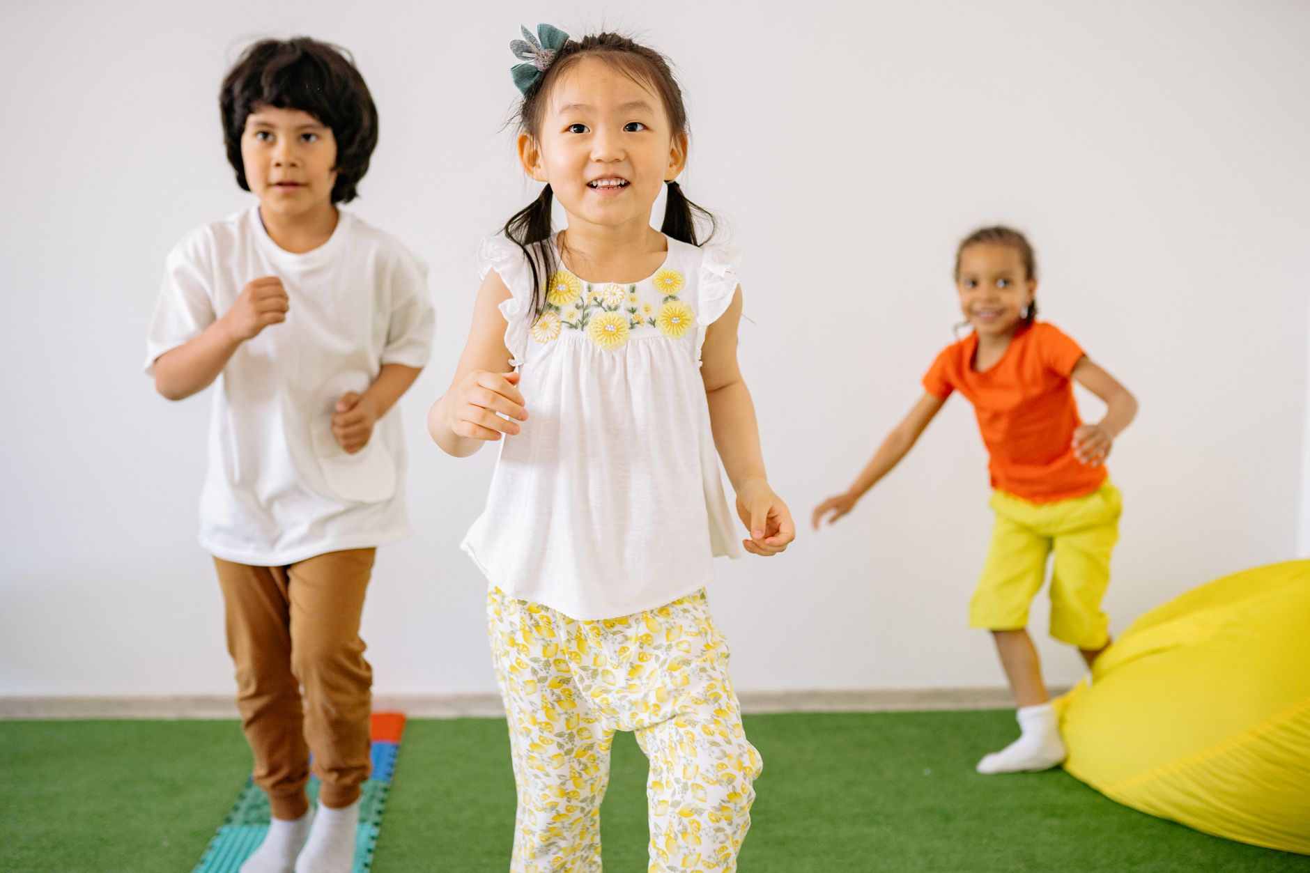 Group of happy diverse children playing indoors, enjoying fun and friendship in a colorful kindergarten setting.