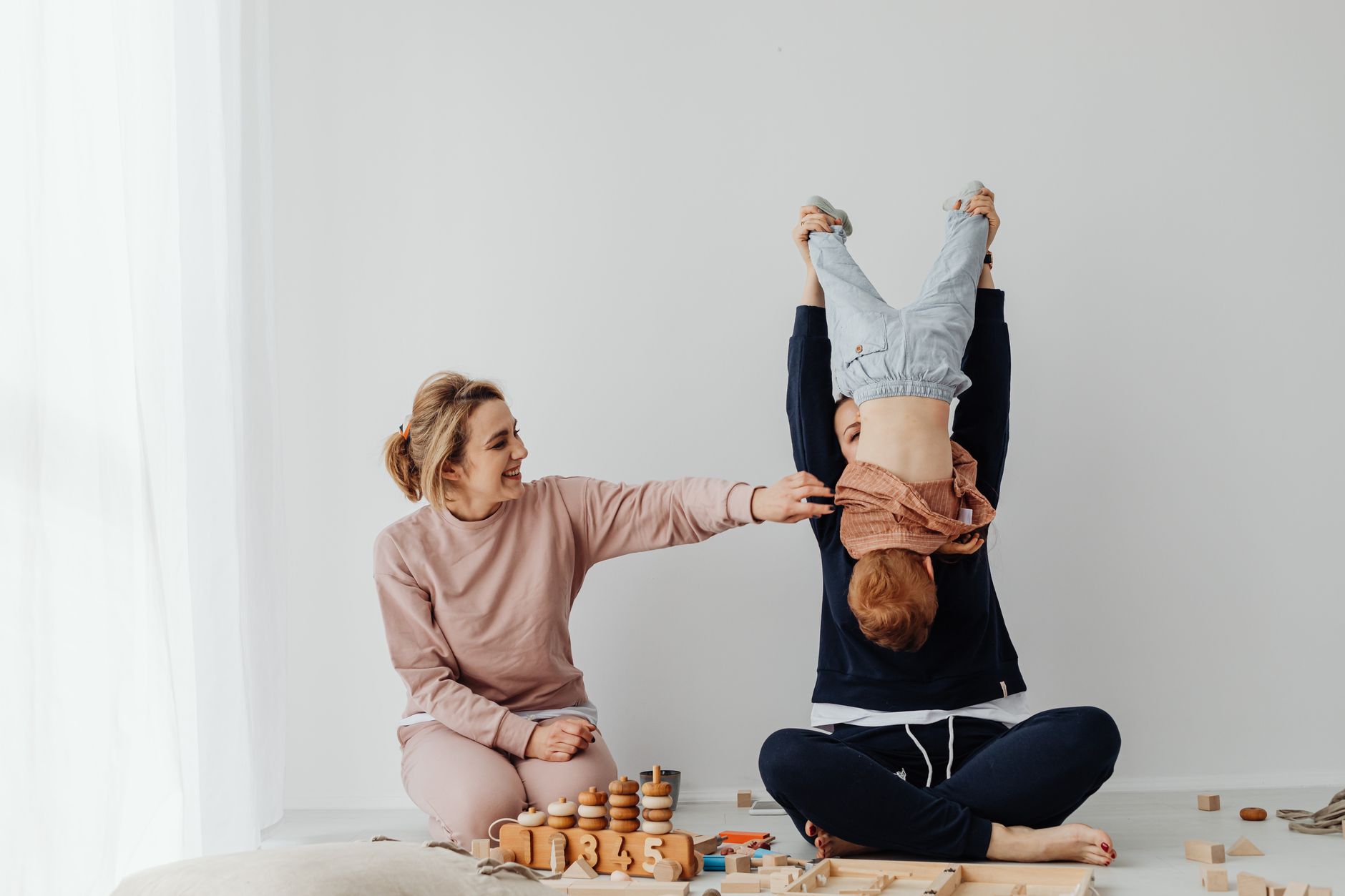 Mother and child enjoying playful time indoors with educational toys.